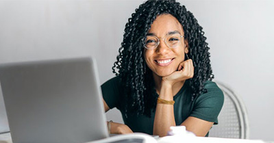 Young woman at her laptop smiling